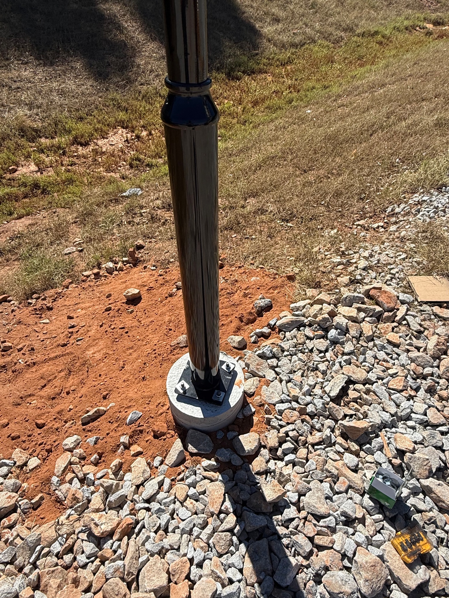 Finished pole base secured to concrete footing